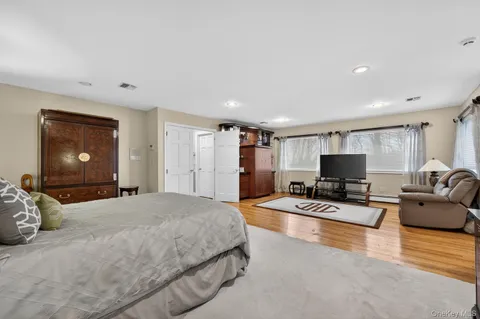 a large white kitchen with kitchen island a stove a sink and a large window
