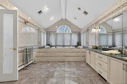 a bathroom with a double vanity sink mirror and shower