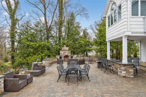 a view of a patio with table and chairs potted plants and a large tree