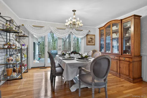 a dining room with furniture a chandelier and wooden floor