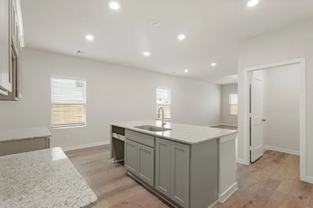 a kitchen with a sink stove and cabinets