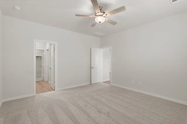 a view of an empty room with a ceiling fan