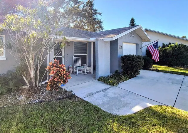 a view of an empty room with window and chandelier fan