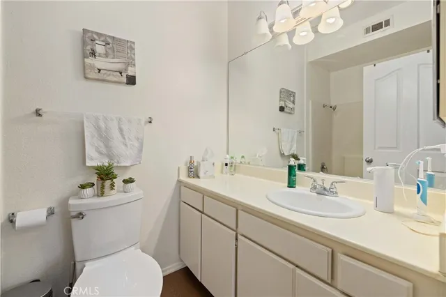 a bathroom with a sink a toilet a large mirror and shower
