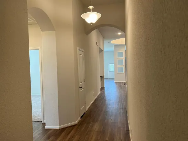 a view of a hallway with wooden floor