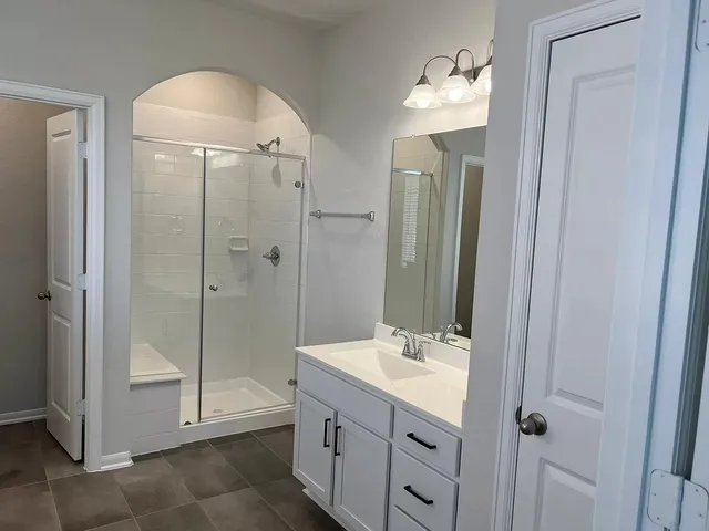 a bathroom with a shower sink and mirror