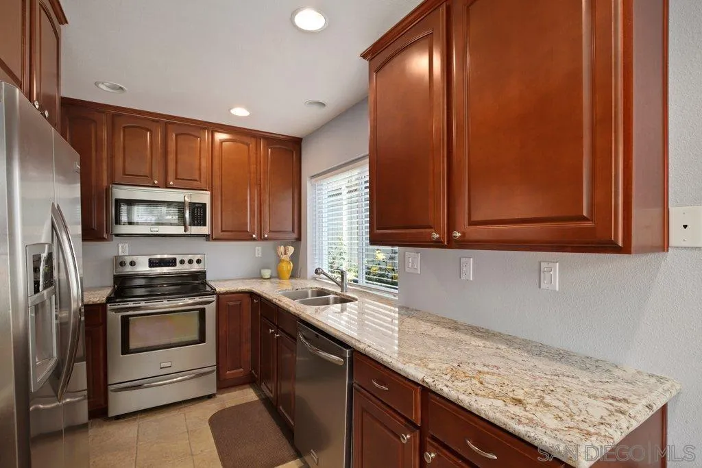13547 Ridley Road San Diego, CA 92129 - Photo 11 of 24 a kitchen with stainless steel appliances granite countertop a sink stove and refrigerator