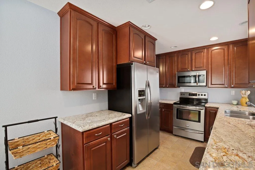 13547 Ridley Road San Diego, CA 92129 - Photo 13 of 24 a kitchen with stainless steel appliances granite countertop a refrigerator stove and microwave