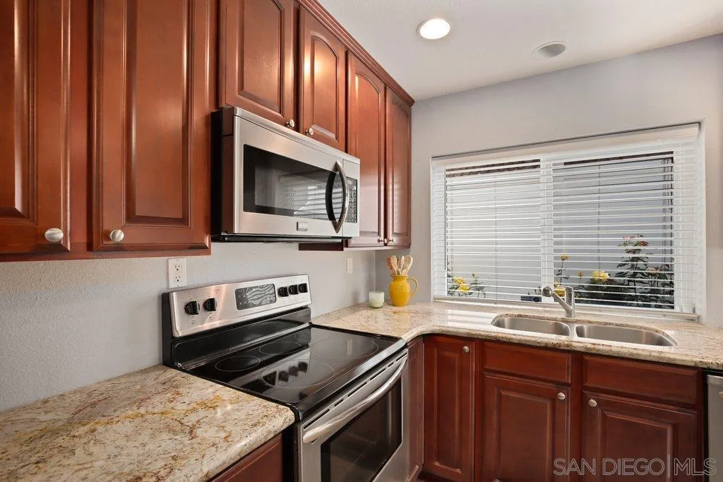 13547 Ridley Road San Diego, CA 92129 - Photo 9 of 24 a kitchen with granite countertop cabinets stainless steel appliances a sink and window