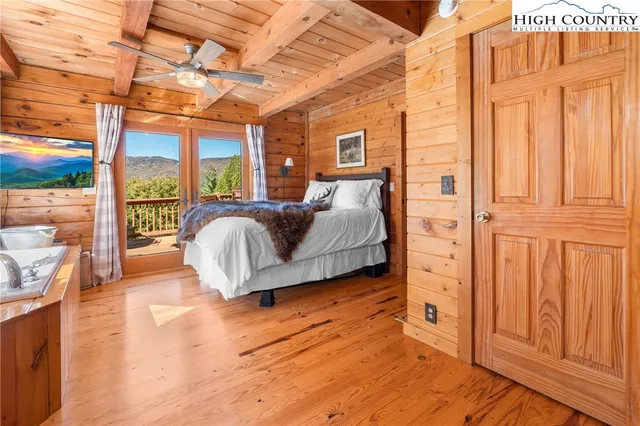 a living room with furniture a wooden floor and next to a window