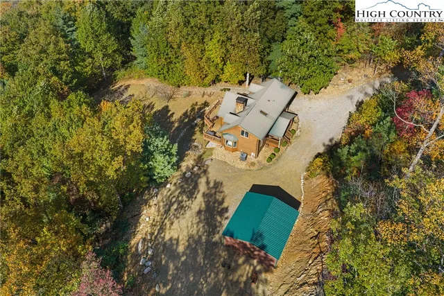 an aerial view of a house with a yard and wooden fence