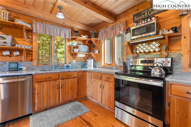 a kitchen with stainless steel appliances granite countertop wooden cabinets a sink and a stove