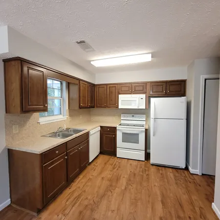 a kitchen with a stove top oven and refrigerator