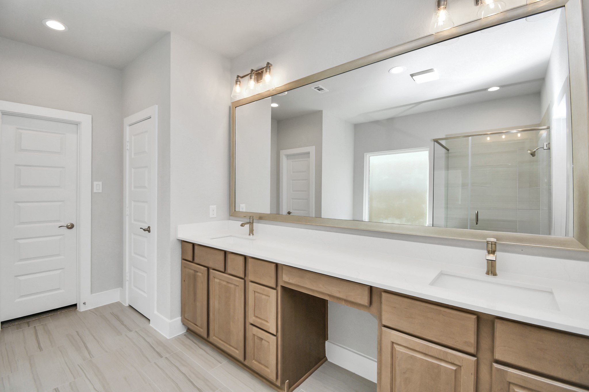 3106 Native Spg Drive Spring, TX 77373 - Photo 22 of 38 Escape to a spa-like oasis in this primary bathroom. Enjoy a walk-in shower with tile surround, a separate garden tub with custom detailing, and an elegant vanity featuring light countertops, modern hardware, and beautiful recessed and vanity lights. Experience luxury and relaxation in every detail. Sample photo of completed home with similar floor plan. Actual colors and selections may vary.