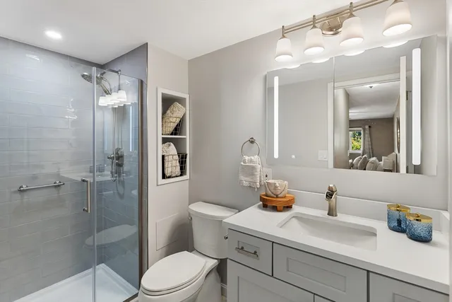 a bathroom with a sink vanity granite toilet and shower