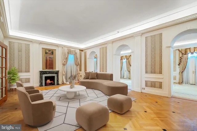 a living room with furniture a fireplace and a large window