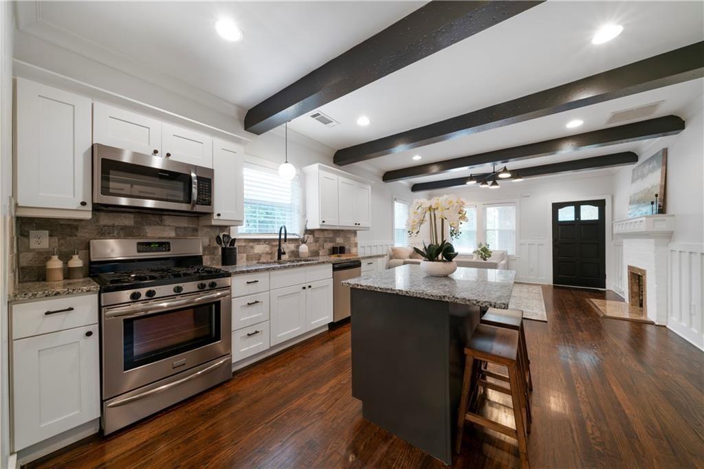 1045 Moreland Avenue Southeast Atlanta, GA 30316 - Photo 13 of 28 a kitchen with stainless steel appliances granite countertop a stove a sink and a microwave