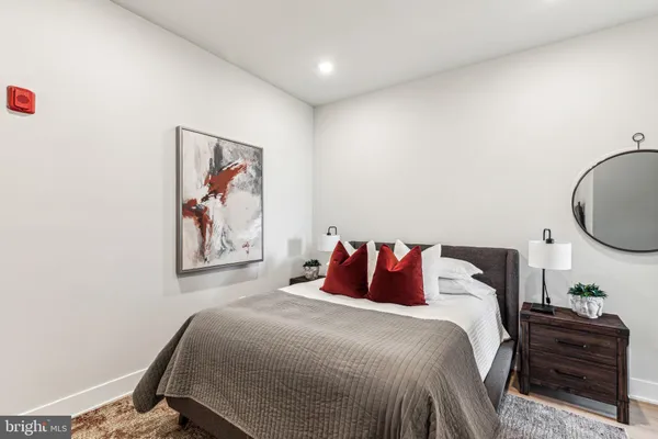 a bedroom with a bed and a painting on the wall