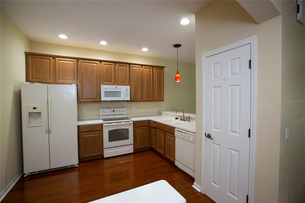 11919 Essington Street New Port Richey, FL 34654 - Photo 3 of 46 a kitchen with stainless steel appliances granite countertop a stove a sink and a refrigerator with wooden floor