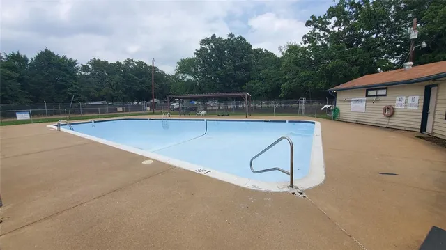 a view of a swimming pool with a bench in the background