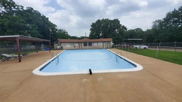 a view of a swimming pool with a patio and yard