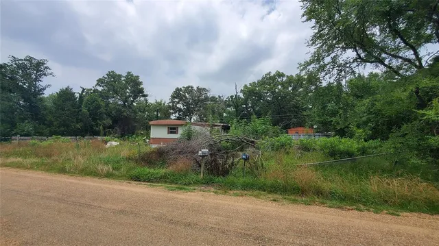a backyard of a house with lots of green space and lake view