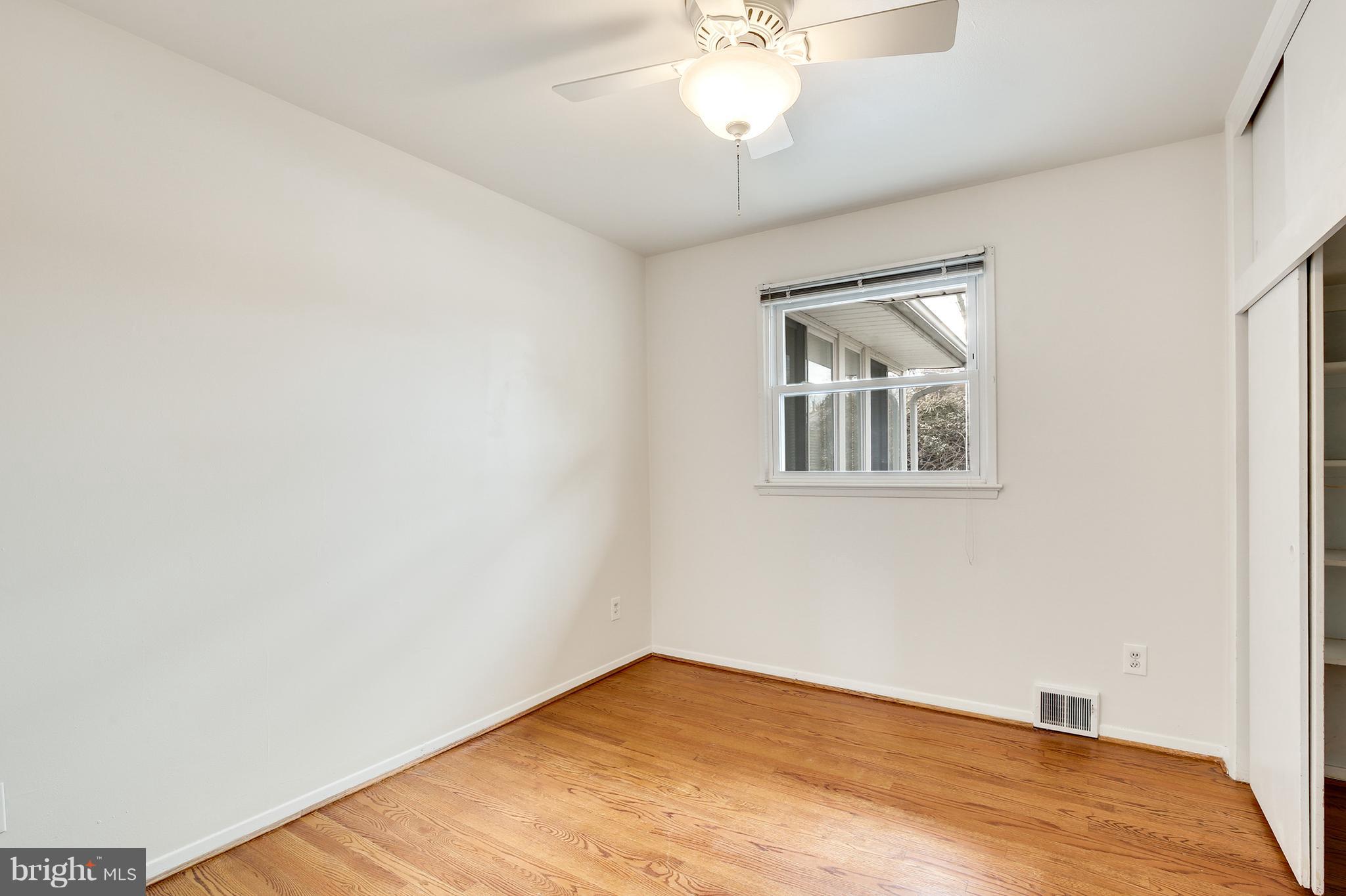 7515 Gresham Street Springfield, VA 22151 - Photo 18 of 36 an empty room with wooden floor chandelier fan and windows