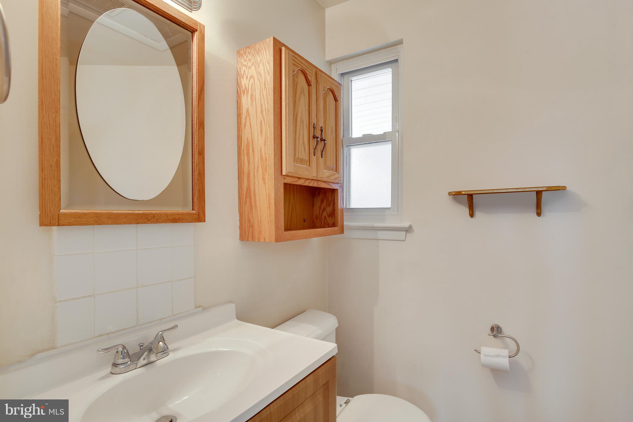 7515 Gresham Street Springfield, VA 22151 - Photo 20 of 36 a bathroom with a sink a mirror and a toilet