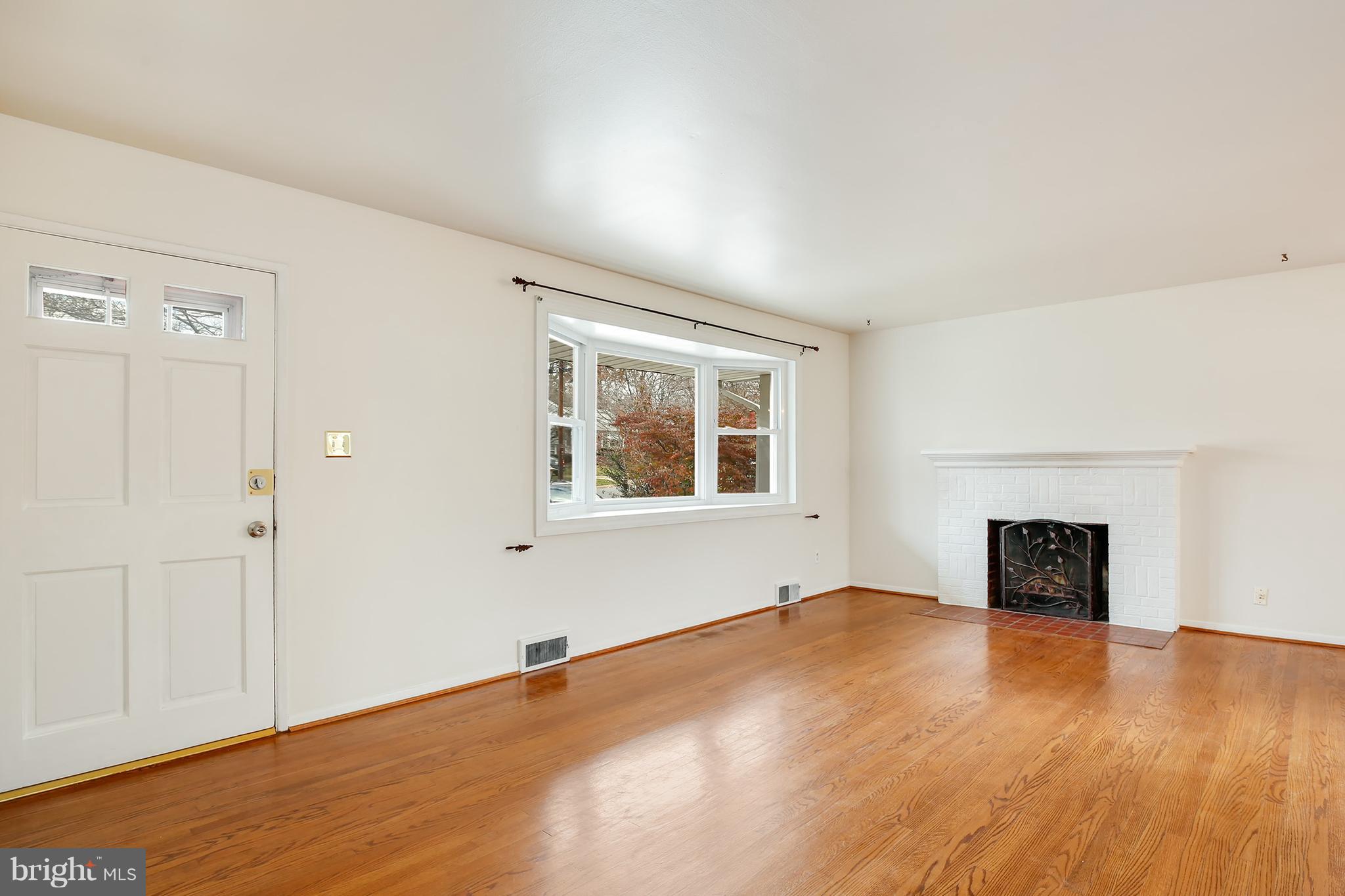 7515 Gresham Street Springfield, VA 22151 - Photo 3 of 36 an empty room with windows and a fireplace