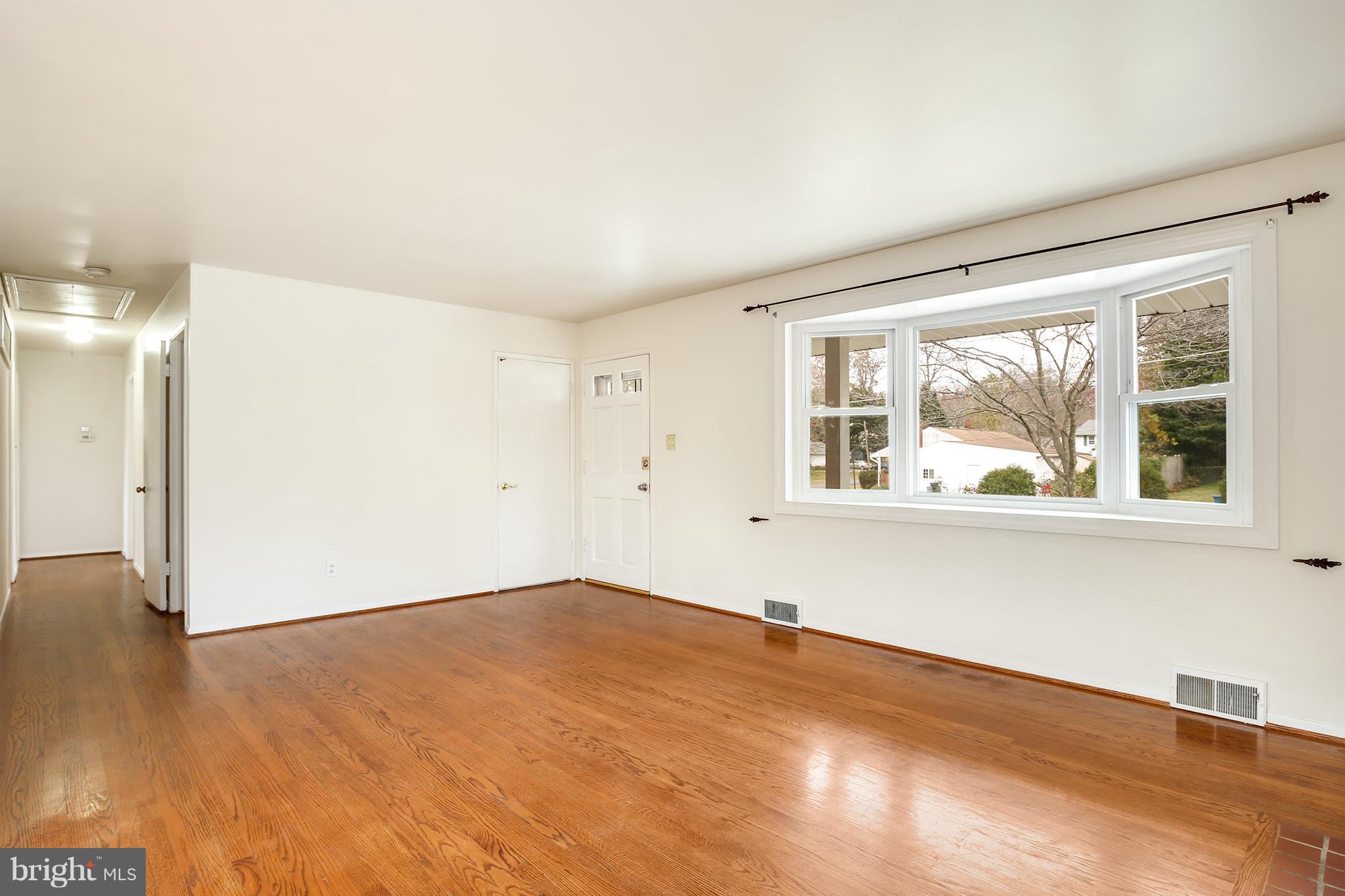 7515 Gresham Street Springfield, VA 22151 - Photo 4 of 36 a view of an empty room with wooden floor and a window