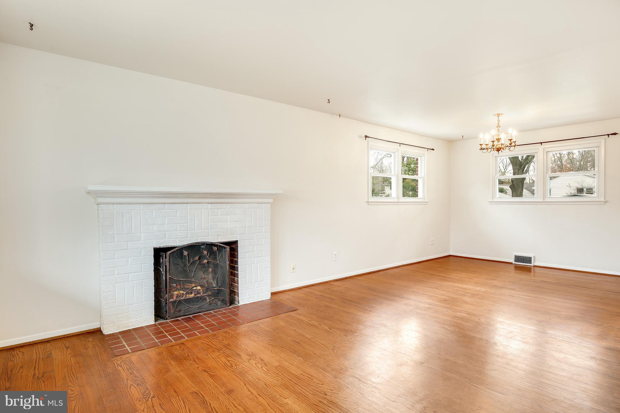 7515 Gresham Street Springfield, VA 22151 - Photo 5 of 36 a view of an empty room with a fireplace and a window