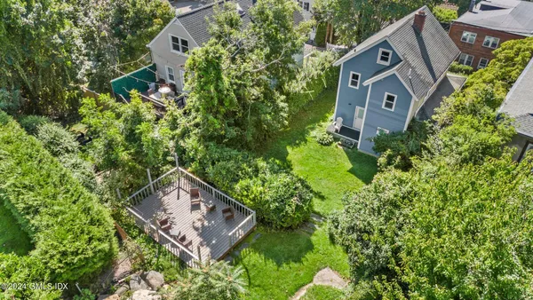 an aerial view of a house with a yard and a large tree