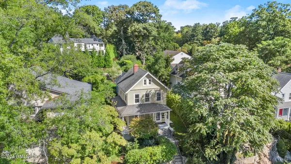 an aerial view of a house with a yard and large trees