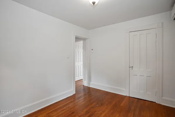 a view of an empty room with wooden floor