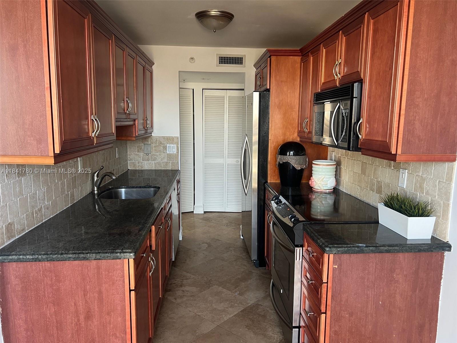 1688 West Avenue, Unit 1005 Miami Beach, FL 33139 - Photo 11 of 34 a kitchen with a sink and cabinets