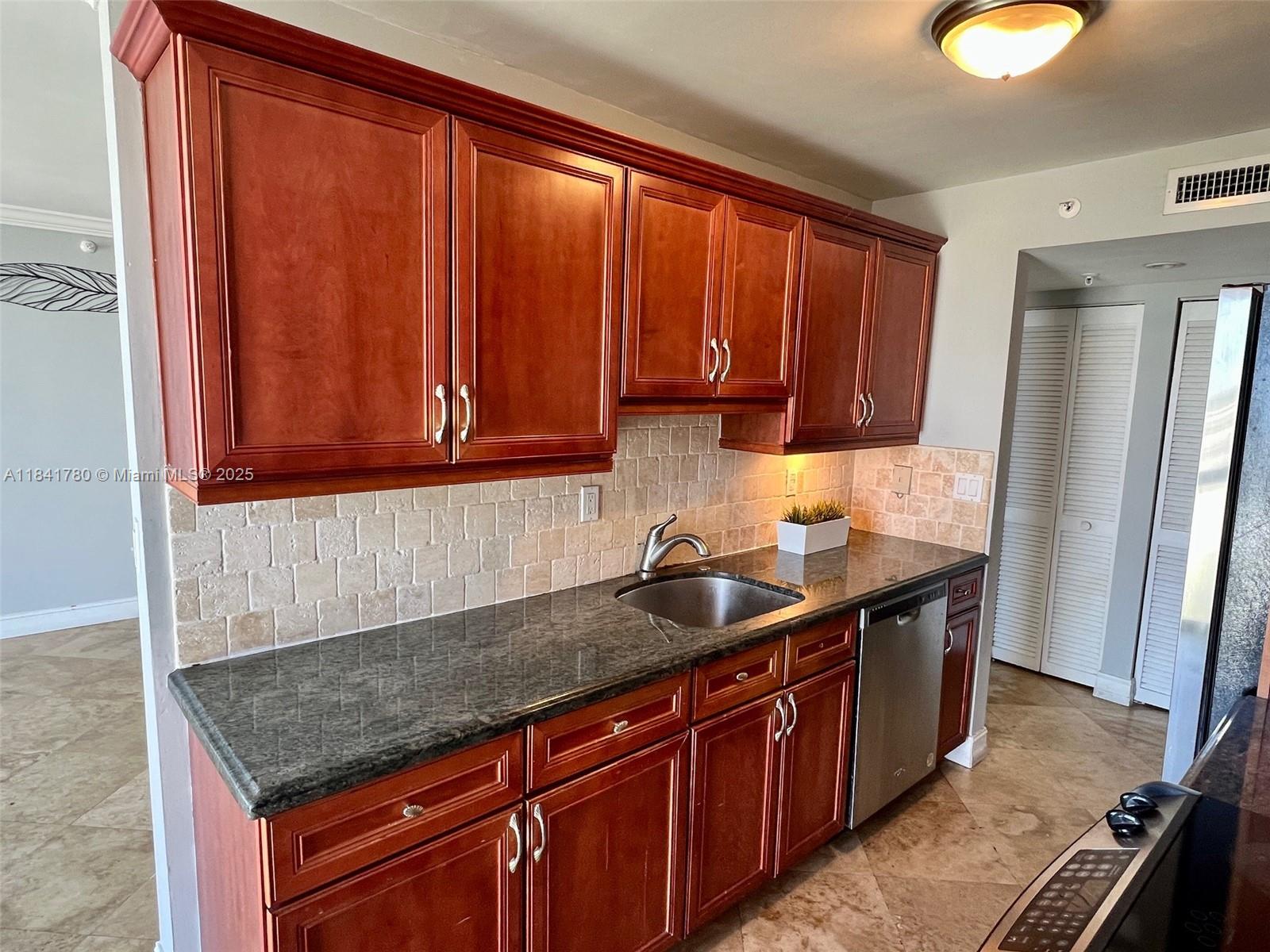 1688 West Avenue, Unit 1005 Miami Beach, FL 33139 - Photo 12 of 34 a kitchen with stainless steel appliances granite countertop a sink stove and refrigerator