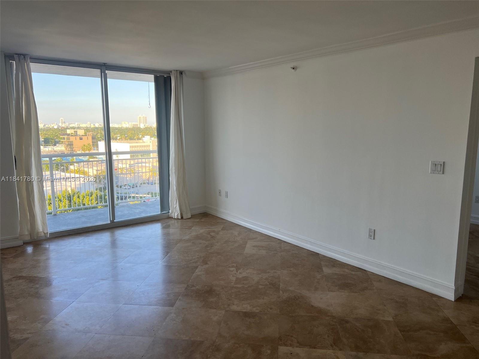 1688 West Avenue, Unit 1005 Miami Beach, FL 33139 - Photo 6 of 34 a view of an empty room with wooden floor and a window