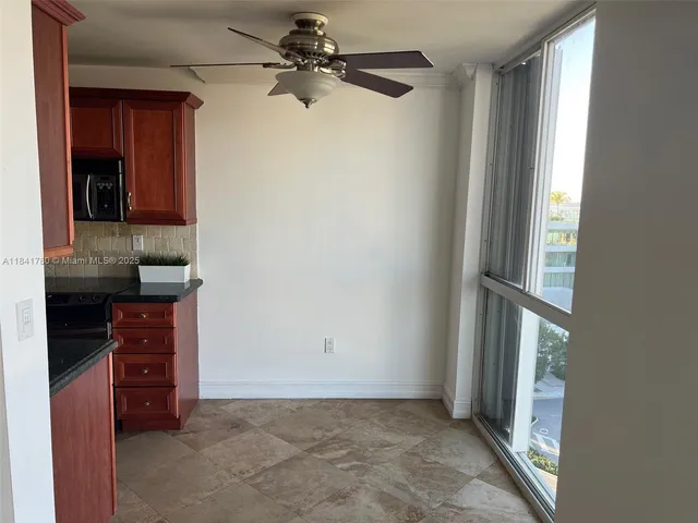 an empty room with a window and a ceiling fan