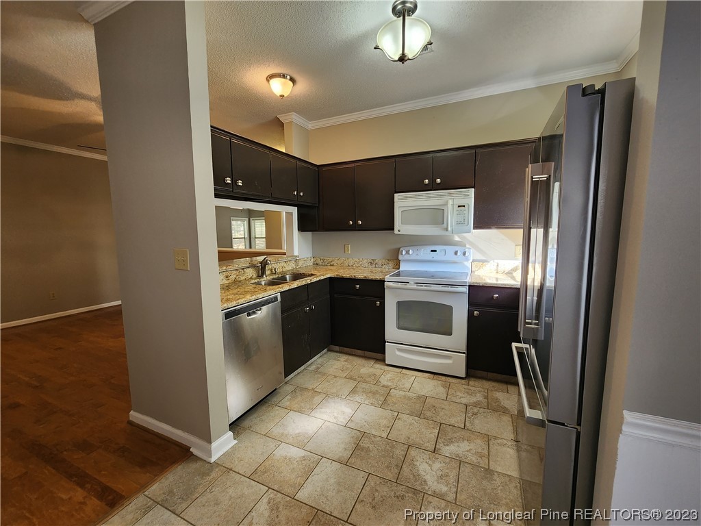 6111 Sunpointe Drive, Unit 104 Raleigh, NC 27606 - Photo 17 of 49 a kitchen with stainless steel appliances a stove a sink and a refrigerator