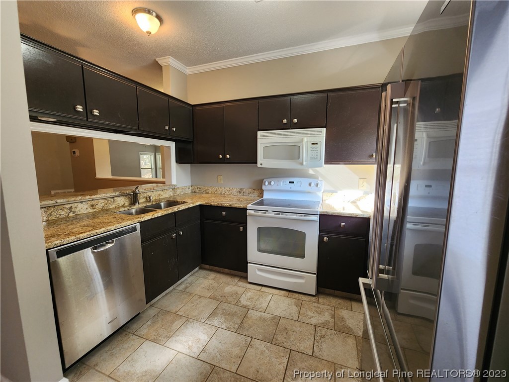 6111 Sunpointe Drive, Unit 104 Raleigh, NC 27606 - Photo 18 of 49 a kitchen with stainless steel appliances granite countertop a refrigerator stove and sink