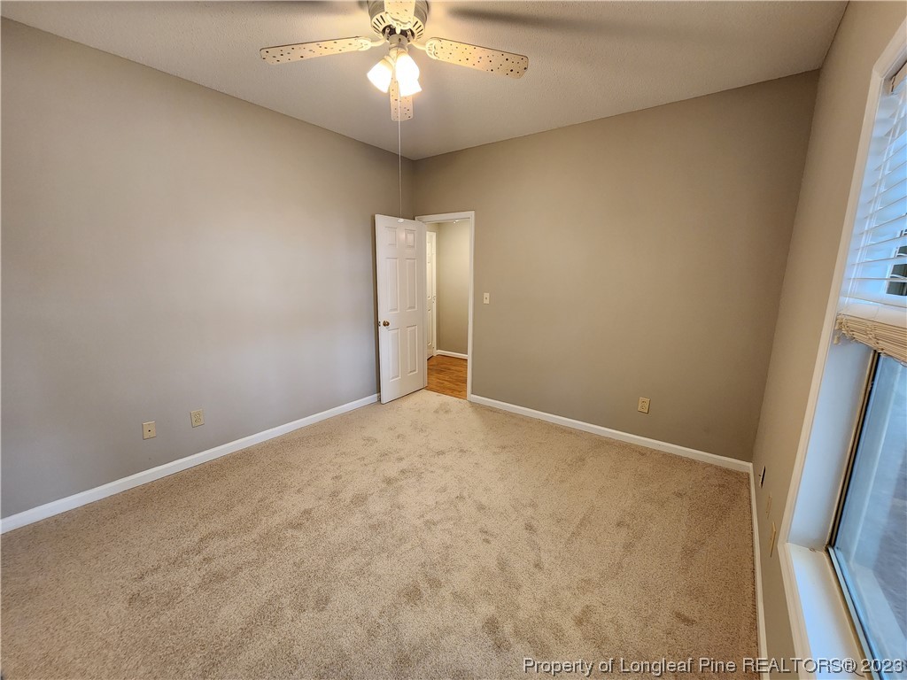 6111 Sunpointe Drive, Unit 104 Raleigh, NC 27606 - Photo 25 of 49 an empty room with a chandelier fan and windows