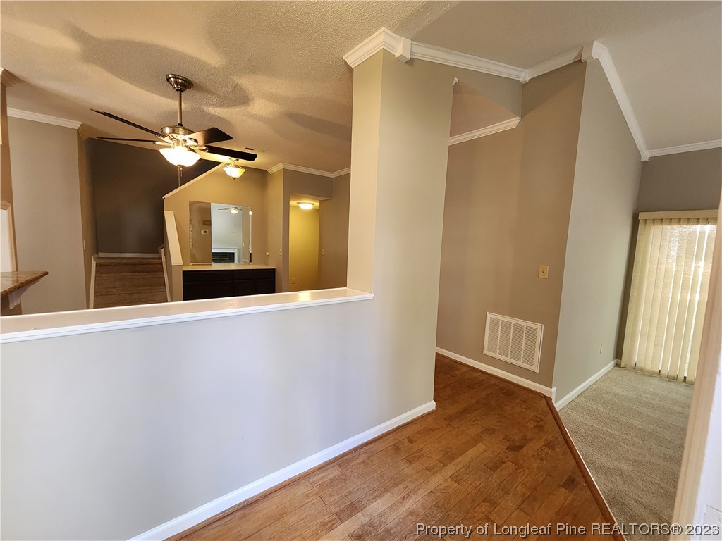 6111 Sunpointe Drive, Unit 104 Raleigh, NC 27606 - Photo 4 of 49 a view of a hallway with wooden floor and a bathroom