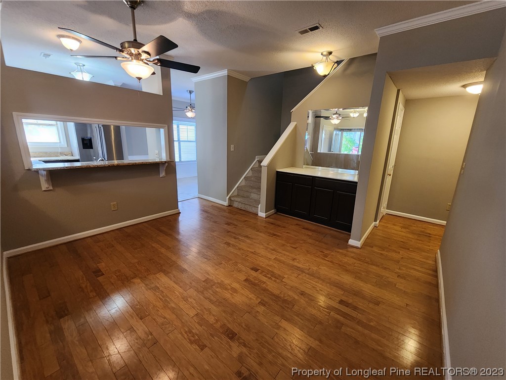 6111 Sunpointe Drive, Unit 104 Raleigh, NC 27606 - Photo 8 of 49 a view of a livingroom with wooden floor and a ceiling fan