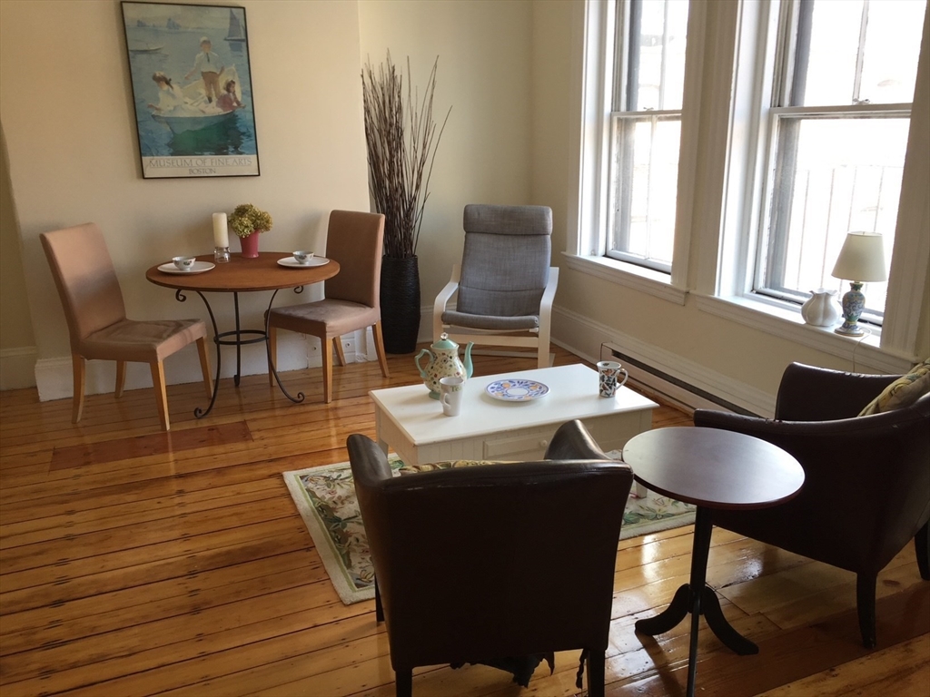 16 Cumberland Street, Unit 1 Boston, MA 02115 - Photo 1 of 8 a view of a dining room with furniture and wooden floor