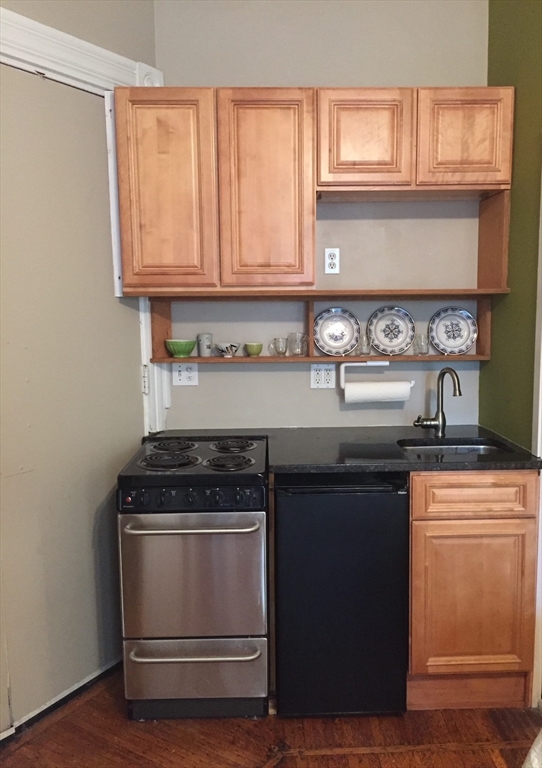 16 Cumberland Street, Unit 1 Boston, MA 02115 - Photo 2 of 8 a kitchen with granite countertop a sink and a stove