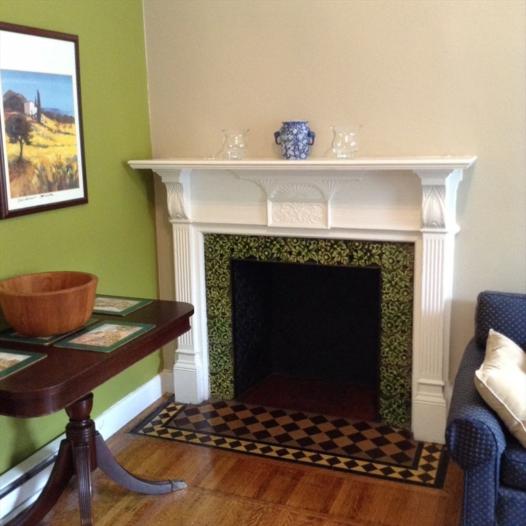 16 Cumberland Street, Unit 1 Boston, MA 02115 - Photo 4 of 8 a living room with furniture and a fireplace