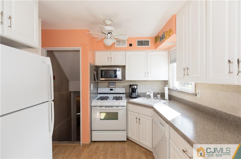 205 North Hill Road Colonia, NJ 07067 - Photo 6 of 25 a kitchen with stainless steel appliances a refrigerator sink and white cabinets