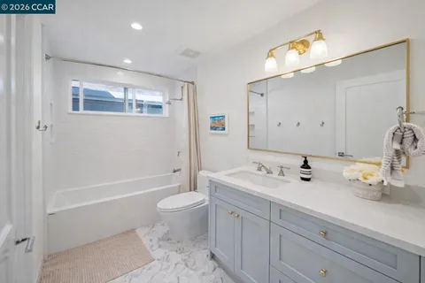 a bathroom with a bathtub shower sink vanity and toilet