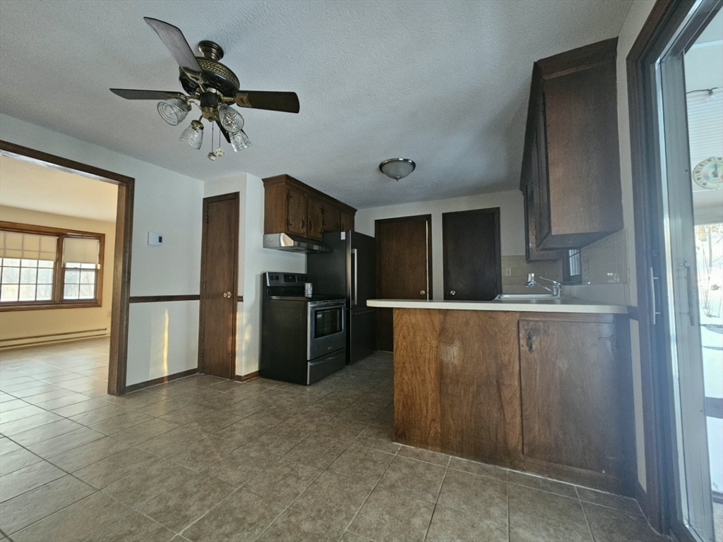 27 Summer Street, Unit 27 Chelmsford, MA 01824 - Photo 4 of 15 a view of a kitchen with a sink and refrigerator