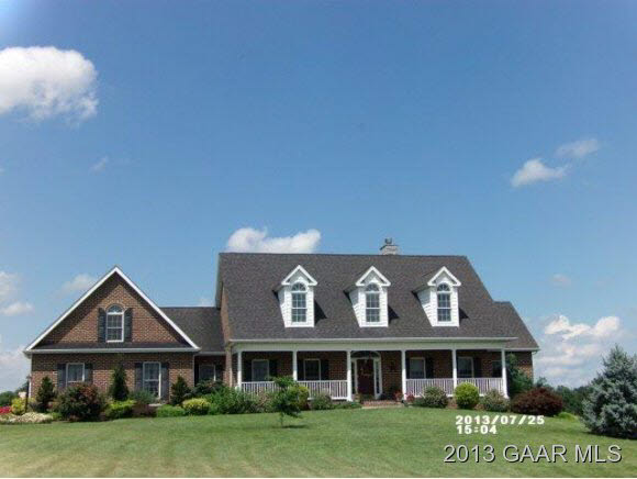 a view of a big house with a big yard and potted plants